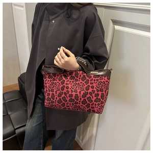 Sac fourre-tout tendance léopard rouge avec détails en cuir porté par un mannequin