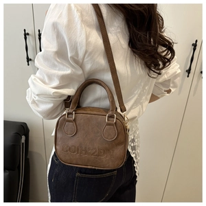 Brown retro textured leather crossbody bag showing embossed lettering on the front side