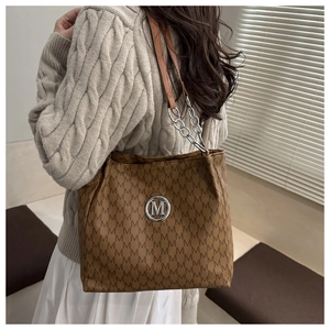 Gros plan du sac cabas marron avec jacquard à motif M et logo argenté élégant