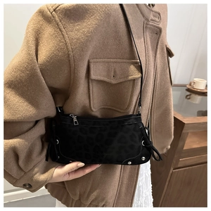 Vue détaillée de la texture léopard noire et des clous argentés sur le sac bandoulière