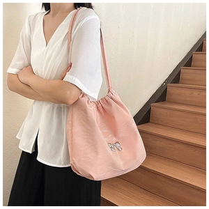 Borsa tote rosa con dettaglio fiocco argento indossata da una modella