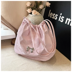 Dettaglio borsa tote rosa chiaro con coulisse e fiocco metallico in argento lucido