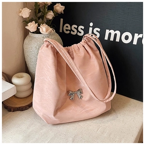 Dettaglio della borsa rosa con coulisse, fiocco in metallo argento e texture plissettata