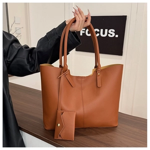 Detailed view of caramel faux leather tote bag with matching envelope pouch on leather strap