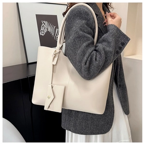 Detail of off-white large tote bag with matching flap pouch on gray wool coat
