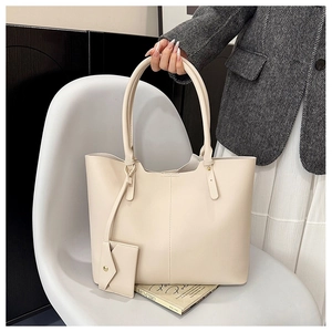 Detail of off-white minimalist leather tote bag with a small matching envelope pouch