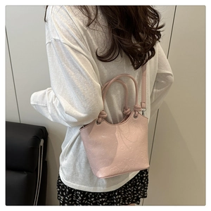 Detailed texture of pink bucket bag featuring embossed love, smile, and crown patterns