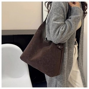 Detail of dark brown matte suede hobo bag with contrast stitching and vintage texture