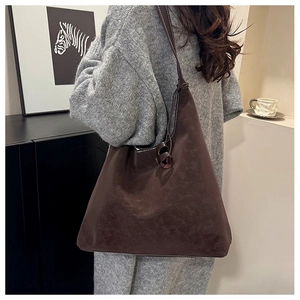 Detail view of deep brown vintage leather tote with white contrast stitching and knotted strap