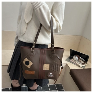Detail view of large brown vintage tote bag with fashion patches in a commute scene