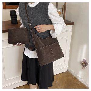 Detail of dark brown retro tote and pouch set with white stitching and wide strap