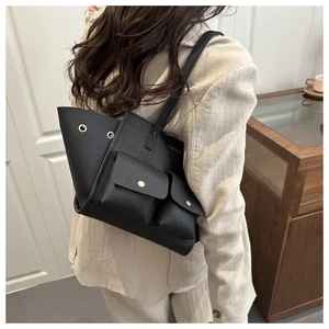 Dettaglio borsa tote nera a grana di litchi con tasche dorate e logo FASHION inciso