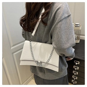 Détail du sac à bandoulière blanc avec texture diagonale et chaîne en métal argenté