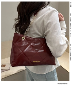 Dettaglio borsa shopper trapuntata bordeaux con catena dorata e motivo a rombi