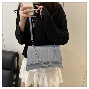 Détail du sac sablier bleu clair texturé avec boucle B argentée et bandoulière
