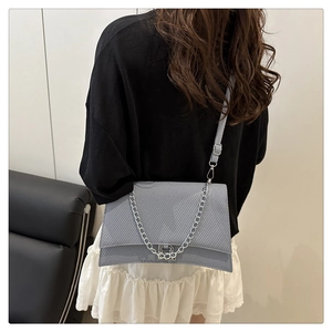 Détail du sac à bandoulière bleu clair en forme de sablier avec texture embossée et chaîne