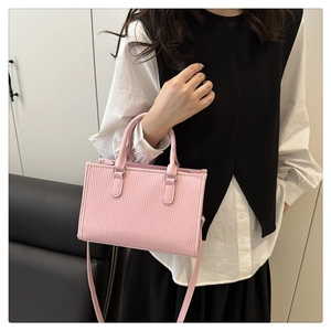 Borsa tote rosa con trama a pieghe e doppi manici indossata da una modella per la taglia