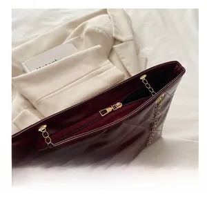 Dettaglio della cerniera dorata e del motivo trapuntato sulla borsa tote color bordeaux