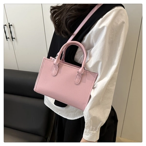 Dettaglio della borsa tote rosa con strisce verticali e accenti metallici argentati