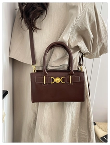 Dettaglio della borsa a tracolla vintage marrone scuro con chiusura in metallo dorato a cuore