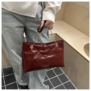 Dettaglio borsa shopper trapuntata bordeaux con catena dorata e scritta Fashion