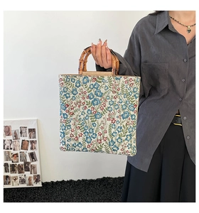 Side view of floral tapestry shoulder bag with vintage bamboo handle and woven edges