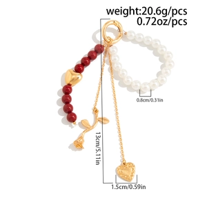 Dettaglio del portachiavi da 13cm con perline rosse, perle e ciondolo a cuore dorato