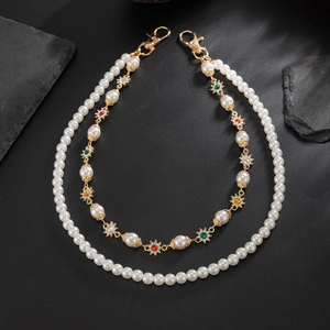 Détail d'une chaîne en perles et étoiles dorées avec gemmes colorées et fermoirs mousquetons