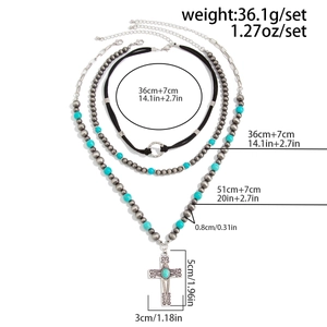 Close-up of bohemian layered necklace with turquoise beads and large cross pendant