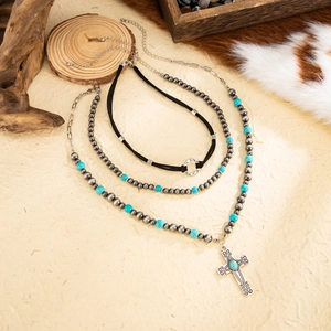 Macro shot of boho turquoise beads and vintage silver cross pendant necklaces