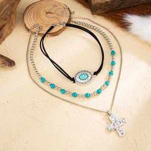 Detail of bohemian 3-piece necklace set with turquoise beads and a silver cross pendant