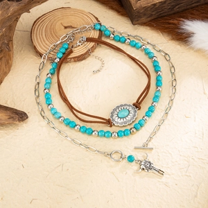 Close-up of bohemian layered necklace with bull head pendant and turquoise beads