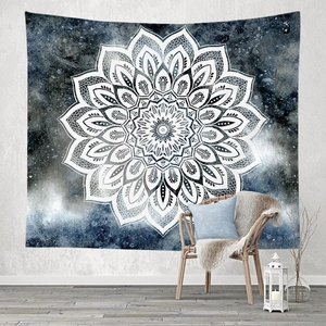 Blue mandala tapestry with starry nebula background hanging on a cozy bedroom wall