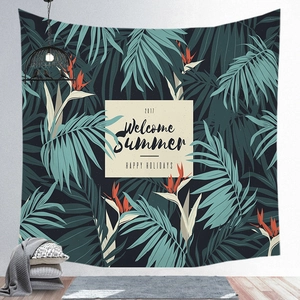 Detail of tropical palm leaf tapestry featuring Welcome Summer text on a white wall