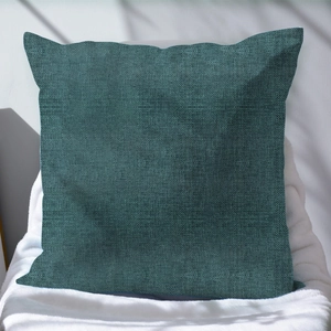 Tessitura dettagliata della federa quadrata in lino verde scuro su tappeto bianco