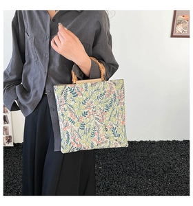 Detail shot of vintage floral jacquard tote bag with elegant natural bamboo handles