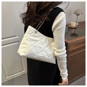 Dettaglio della borsa trapuntata bianca con catena dorata e scritta FASHION