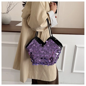 Detail of purple sequin tote bag showing reflective texture and black leather handles