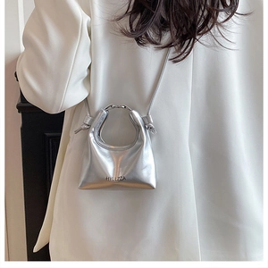 Silver metallic crescent mini crossbody bag with round handle and letter branding