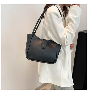 Dettaglio della borsa tote nera opaca minimalista con bordo ondulato e fibbia chic