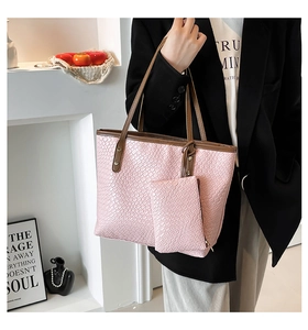 Dettaglio della borsa tote rosa intrecciata con trama a scacchi e manici marroni