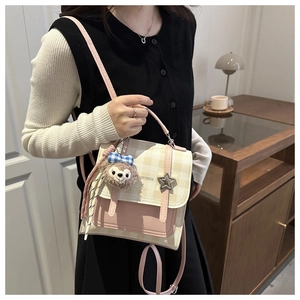 Detailed close-up of pink checkered crossbody bag featuring a star lock and plush charm