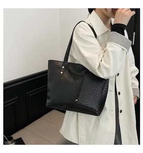 Vista dettagliata della grande borsa tote nera con trama intrecciata e pochette