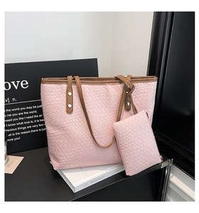 Vista dettagliata della borsa tote rosa intrecciata con manici marroni e pochette