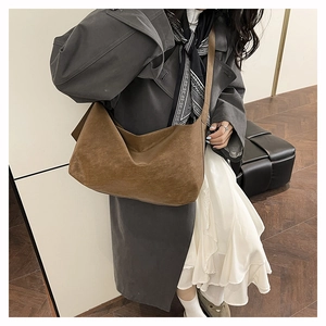 Dettaglio della grande borsa tote in pelle scamosciata marrone scuro con tracolla larga