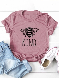 Flat lay di maglietta rosa KIND con stampa ape, abbinata a jeans e scarpe bianche