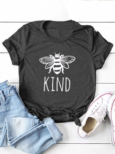 Dettaglio della stampa Bee Kind su maglietta grigio scuro con jeans e scarpe bianche