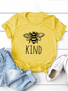 Dettaglio della t-shirt gialla con stampa a forma di ape nera e scritta KIND