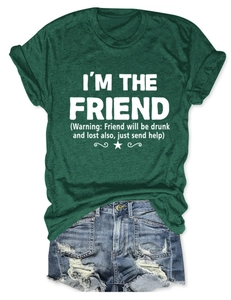 Dettaglio della t-shirt verde scuro con stampa bianca e pantaloncini di jeans strappati