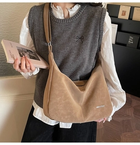 Close-up of retro brown hobo bag in matte leather texture with wide shoulder strap